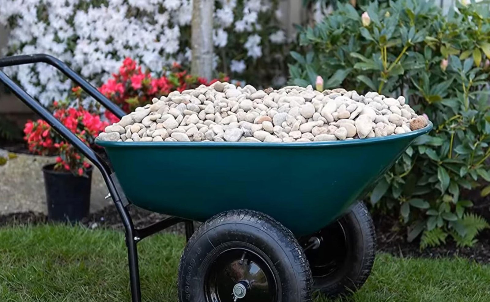 A two-wheeled wheelbarrow filled with construction materials